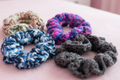Set of 4 handmade crocheted scrunchies in various colors.